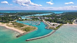 An aerial view of a marina with boats docked, surrounded by residential areas and a beach. - 3-bedroom condo in adorable Elk Rapids with AC and comfort - One block to beach (Elk Rapids)