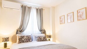 A bedroom with a bed, curtains, wall art, and an air conditioning unit. - The Pine -stylish Thessaloniki Stay Priv Parking (Pavlos Melas)