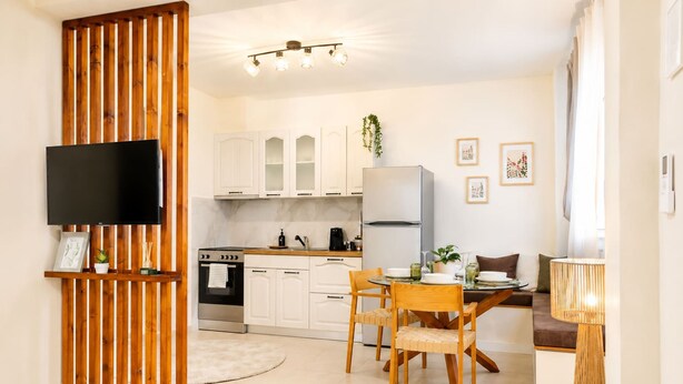 A modern kitchen with white cabinets, a built-in oven, and a dining area with a table and chairs. - The Pine -stylish Thessaloniki Stay Priv Parking (Pavlos Melas)