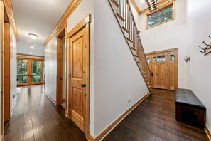 A hallway with wooden doors, a staircase, and a bench. - The Alpine Green Lodge (South Lake Tahoe)
