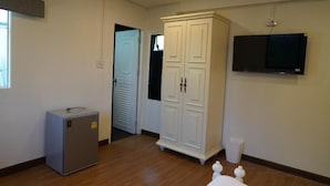 A room with a wardrobe, a television mounted on the wall, and a small refrigerator. - RQ Opsian Ratchada Service Apartments (Bangkok)