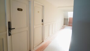 A hallway with doors numbered 102 and 13, leading to rooms. - RQ Opsian Ratchada Service Apartments (Bangkok)