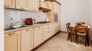 Een keuken met een spoelbak, fornuis en kastjes.