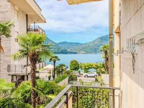 Ein Wohngebäude mit Balkon, mit Blick auf einen See und Berge.