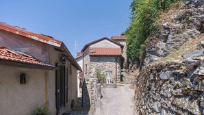 A narrow stone pathway between buildings with traditional architecture, including a stone wall and a tiled roof. - Beautiful private villa for 4 people with WIFI and terrace (Bagnone)