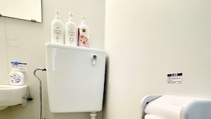 Um banheiro pequeno e limpo, com vaso sanitário, pia e suporte para papel higiênico.