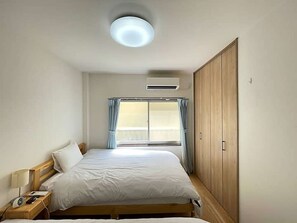 Une chambre à coucher avec un lit, une table de chevet et une armoire.