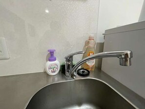 Ein Küchenspüle mit modernem Wasserhahn und zwei Seifenspendern.
