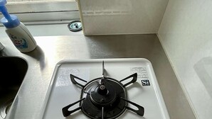 En vit gasspis med fyra brännare, en kontrollpanel och en vit vredknopp.