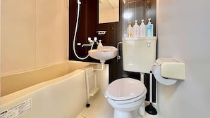 Een moderne badkamer met bad, toilet, wastafel en douche.