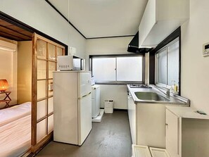 A compact kitchen with a refrigerator, microwave, sink, and window. - LunaStay Apartments - 302 (東京)