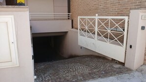 A gated entrance with a brick wall and a tiled floor.