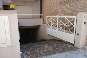A gated entrance with a brick wall and a tiled floor.
