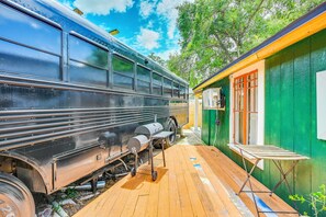 A train parked next to a green building with a wooden deck. - Grill & Porch! Extended Escape, 2 Mi to Ybor City (Tampa)