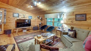 A cozy cabin interior with a wooden ceiling, a television, a fireplace, and a sofa. - Hot Tub & Game Room! Wooded Retreat in Blue Ridge (Blue Ridge)