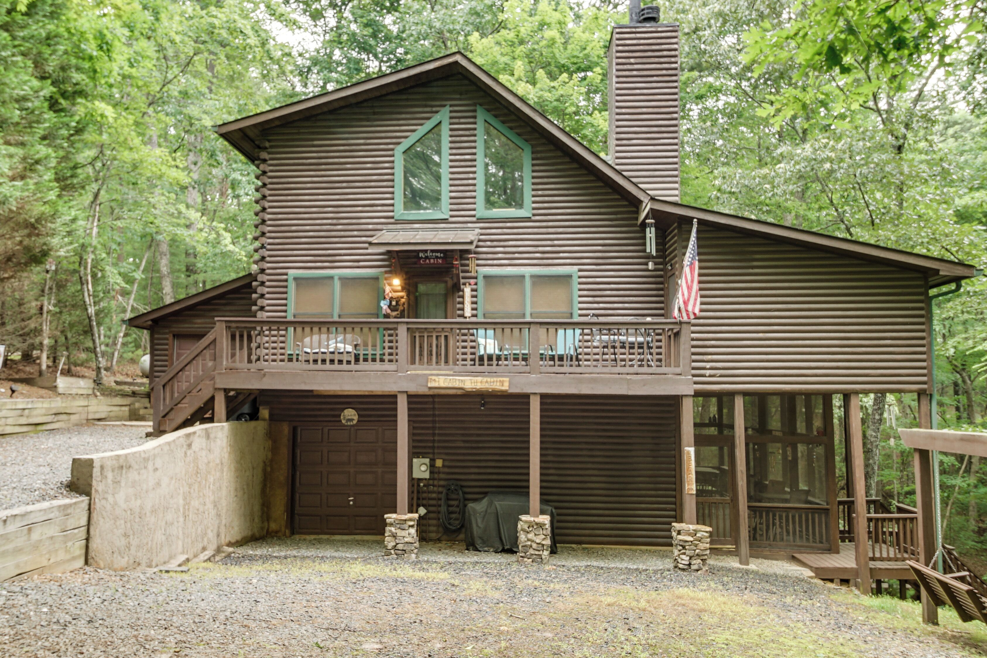 A cabin with a porch, a chimney, and a flag.