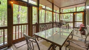 A covered outdoor dining area with a table and chairs, large windows, and a 'Welcome' sign. - Hot Tub & Game Room! Wooded Retreat in Blue Ridge (Blue Ridge)