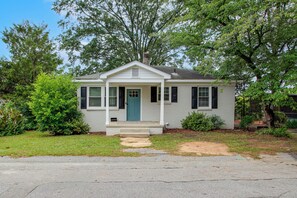 A single-story house with a front porch, a front door, and a small front yard.