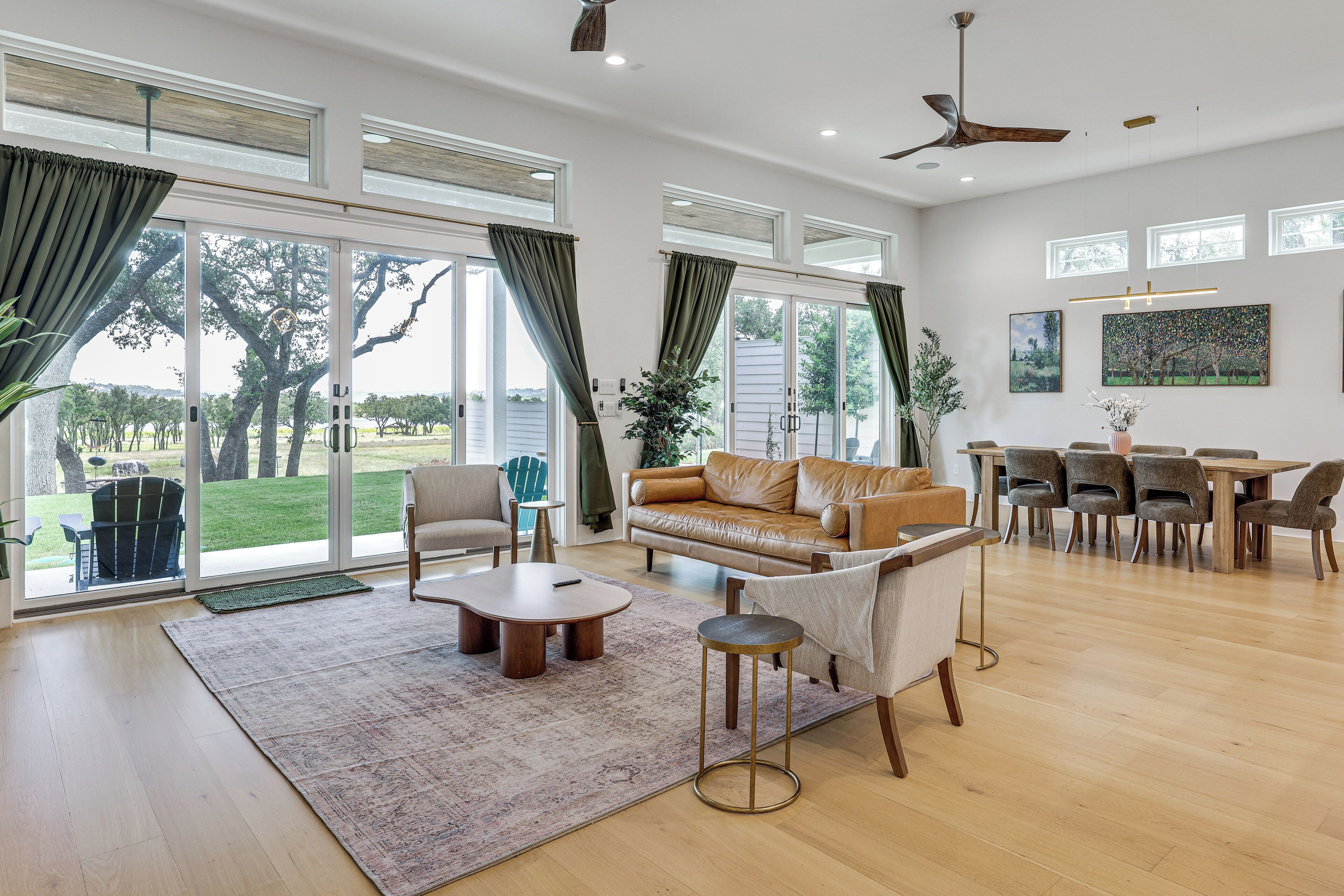 A spacious living room with a large sofa, a coffee table, and a dining area with chairs and a table.