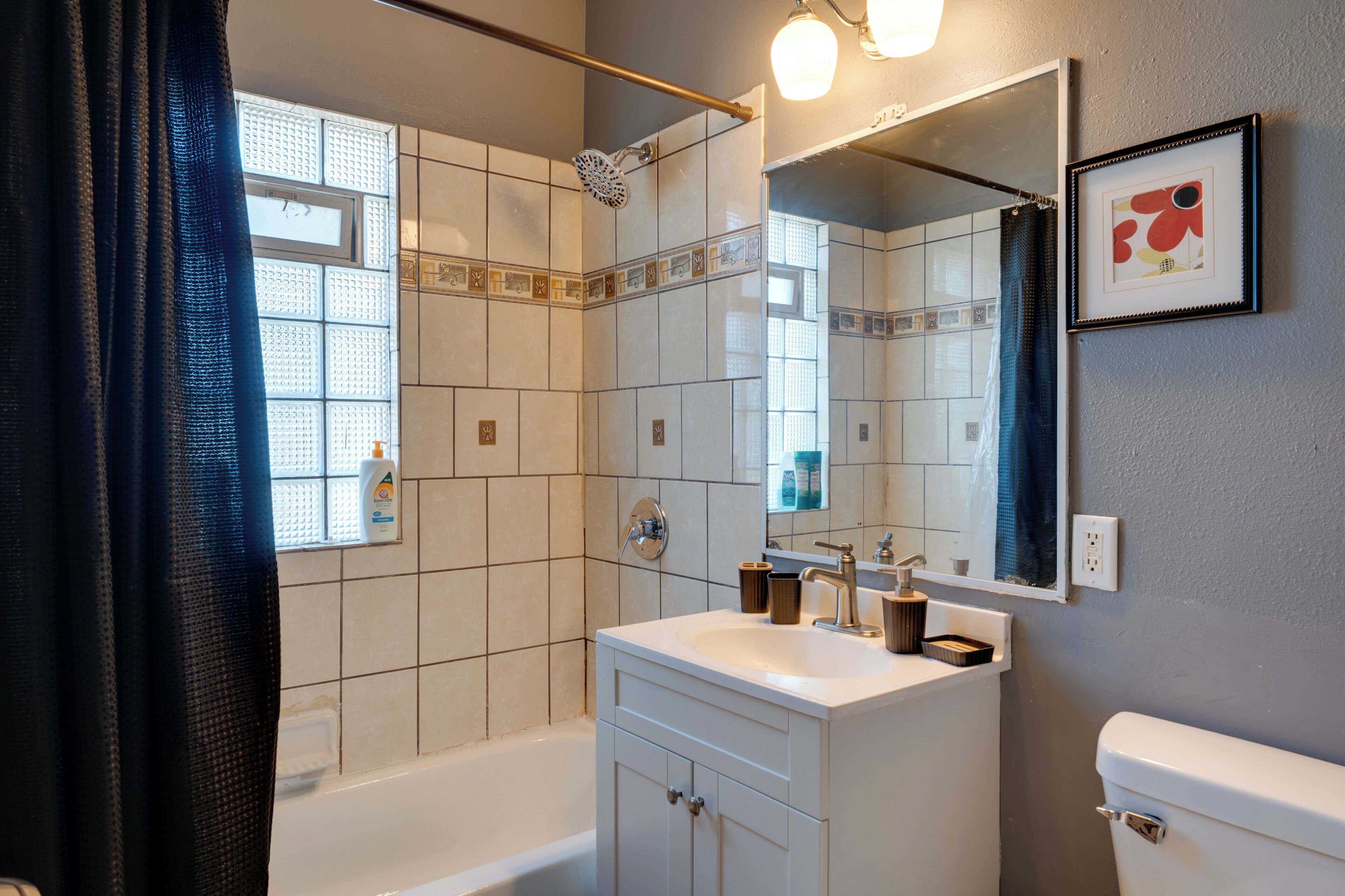 A bathroom with a bathtub, a sink, a mirror, and a shower.