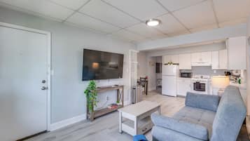 A modern apartment with a living room, kitchen, and dining area.
