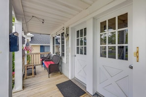 A covered porch with a wooden floor, a small table, two chairs, and an American flag. - Walk to Beach, Boardwalk, Restaurants: Asbury Park (Ocean Grove)