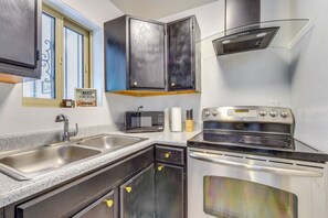 A kitchen with stainless steel appliances, a double sink, and a window with a view. - Tucson Home Base Near I-10, 5 Mi to Downtown! (Tucson)