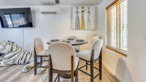 A dining area with a round table, four chairs, a ceiling fan, and a painting on the wall. - Tucson Home Base Near I-10, 5 Mi to Downtown! (Tucson)