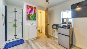 Une cuisine moderne équipée d’un réfrigérateur, d’un four à micro-ondes et d’une petite table à manger.