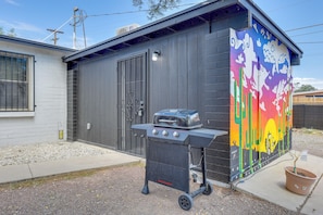 A black barbecue grill with a built-in oven, a potted plant, and a colorful mural on the building's exterior. - Desert Studio 5 Mi to Dtwn Tucson w/ Shared Yard (Tucson)