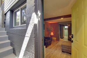 Eine Treppe führt zu einem Raum mit Fenster, Tür und Lampe.