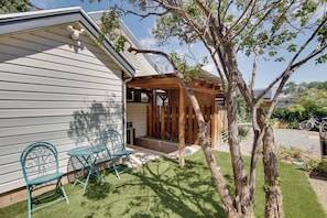 A house with a covered porch, two outdoor chairs, a tree, and a bicycle in the background. - Walk to SSU & Shakespeare Fest! Colorful Retreat (Cedar City)