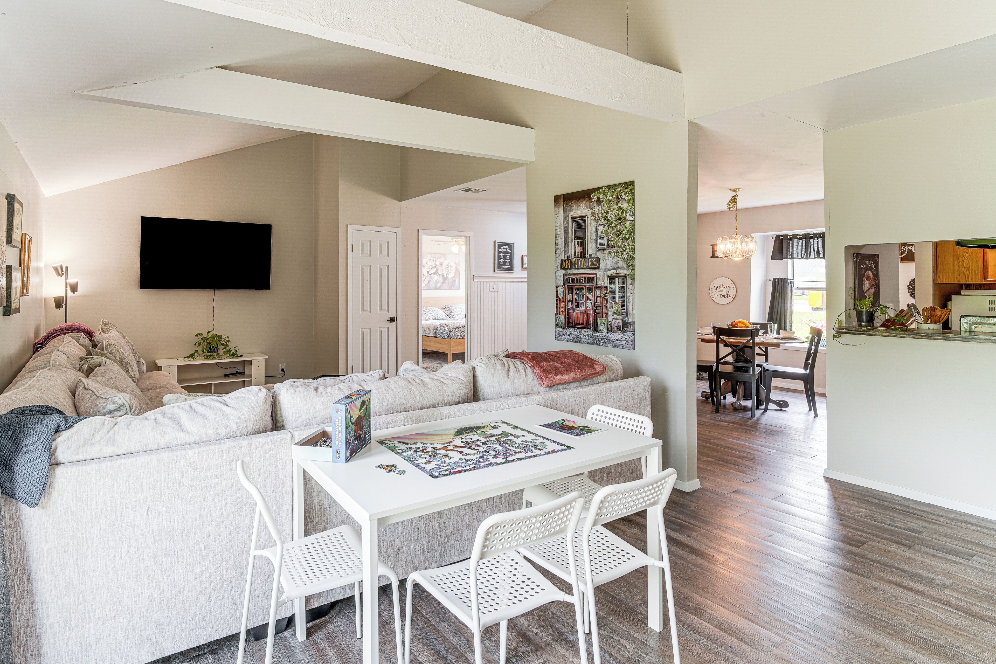 Un salon avec un canapé, une table basse et un téléviseur fixé au mur.