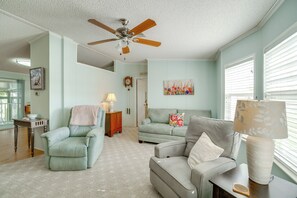 A living room with a ceiling fan, two sofas, a table with a lamp, and a painting on the wall. - Active-adult Community! Port Charlotte Home, Lanai (Punta Gorda)