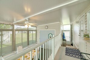 A staircase with a white railing leading to a landing with a clock and a door. - Active-adult Community! Port Charlotte Home, Lanai (Punta Gorda)
