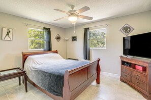 A bedroom with a bed, a ceiling fan, a dresser, a TV, and two windows with curtains. - Near Golf Courses! Cozy Family Home in Englewood (Englewood)