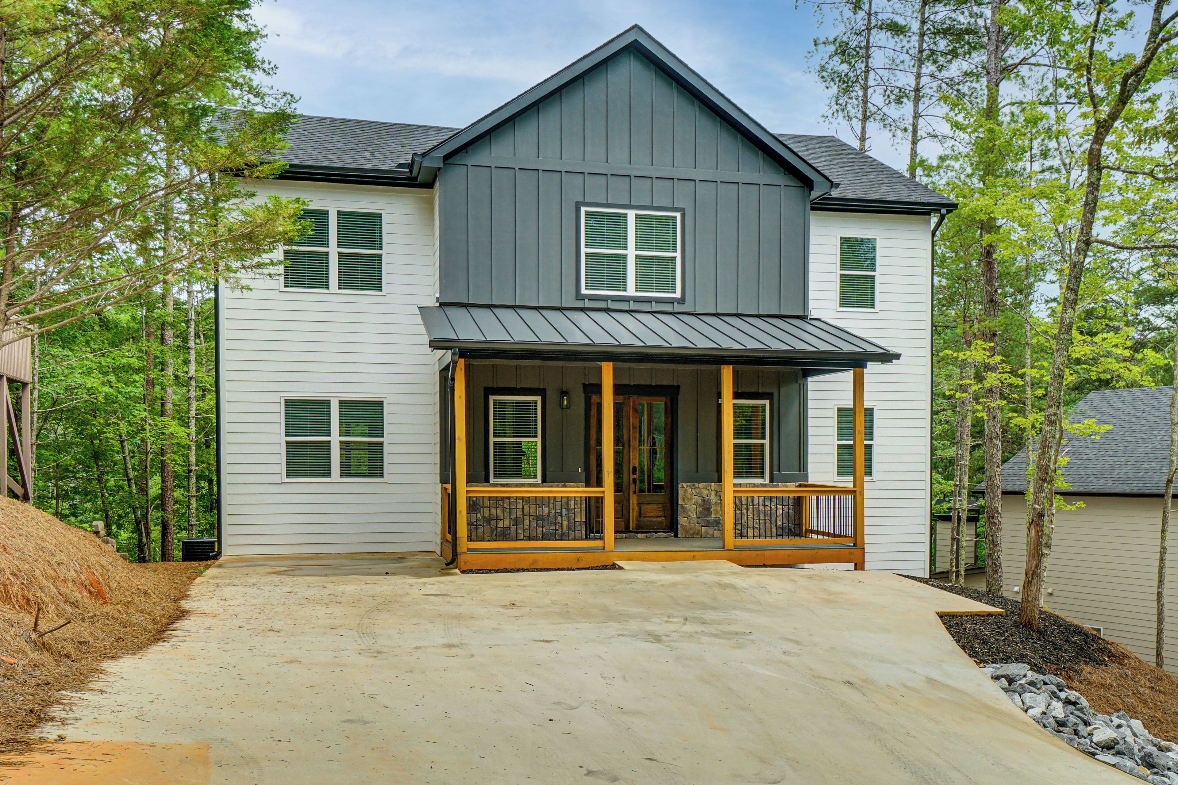 A two-story house with a porch, a front door, and a driveway.