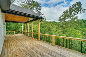 A wooden deck with a railing, overlooking a forested area. - Luxe 4BR Cabin at Innsbruck Resort in Helen (Helen)