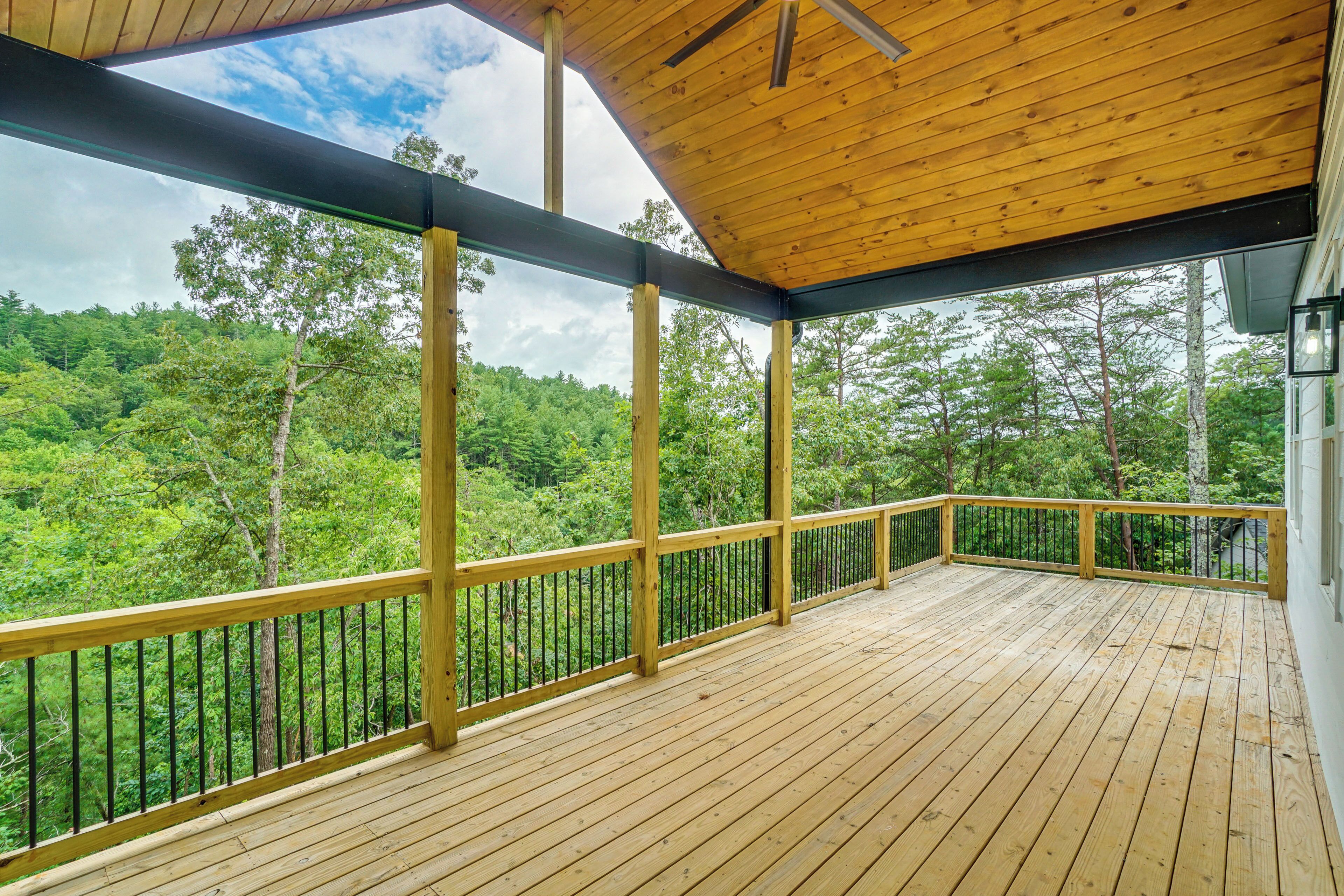 Eine Holzterrasse mit Blick auf ein bewaldetes Gebiet.