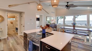 A spacious kitchen with an island, wooden ceiling beams, and a view of the sea. - Family & Angler Friendly! Lake Minnewaska Retreat (Glenwood)