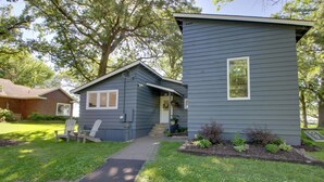 A two-story house with a front porch, a small garden, and a paved driveway. - Family & Angler Friendly! Lake Minnewaska Retreat (Glenwood)