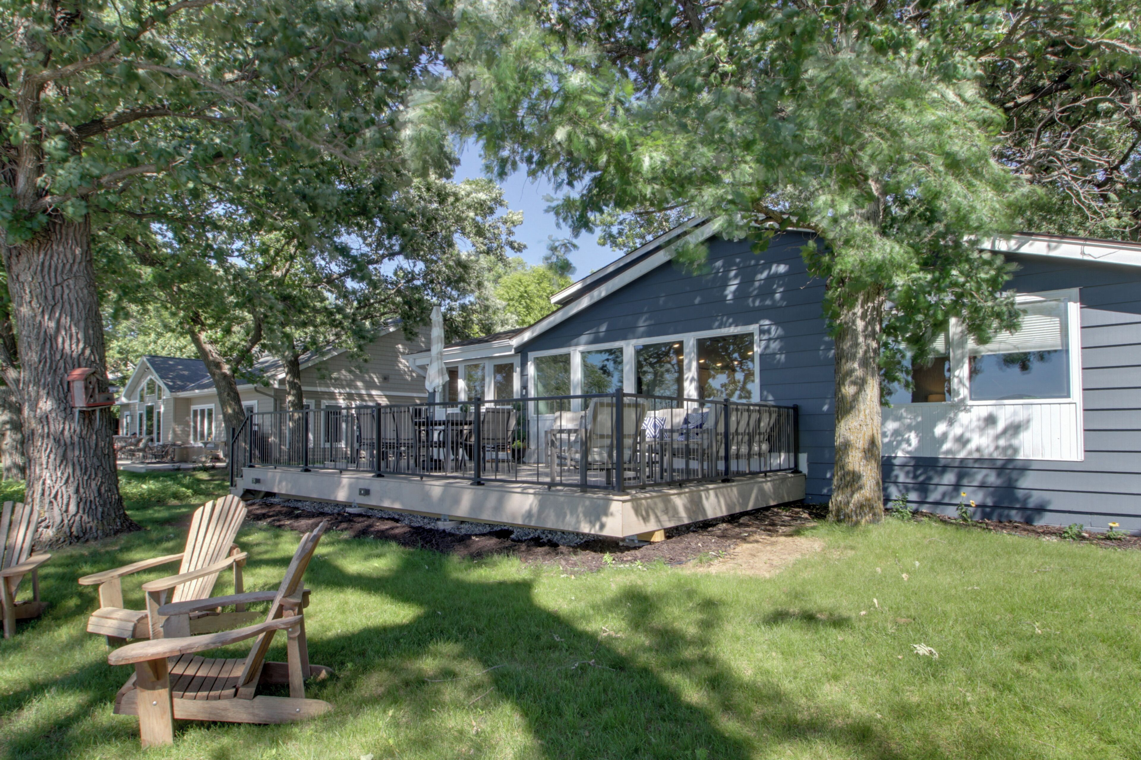 A house with a covered porch, a lawn, and a large tree.