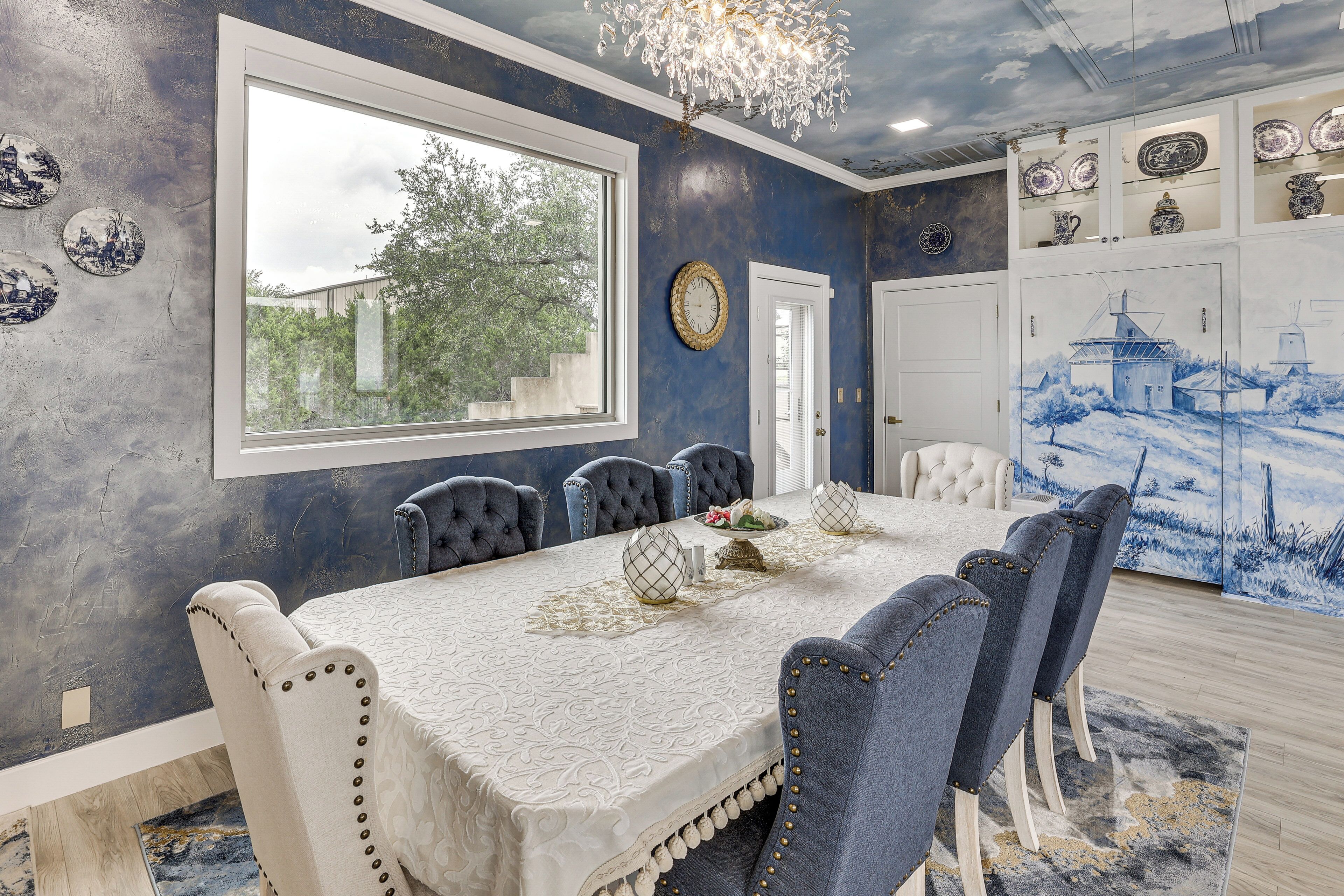 Une salle à manger avec une grande table, des chaises et une vue sur l’extérieur.