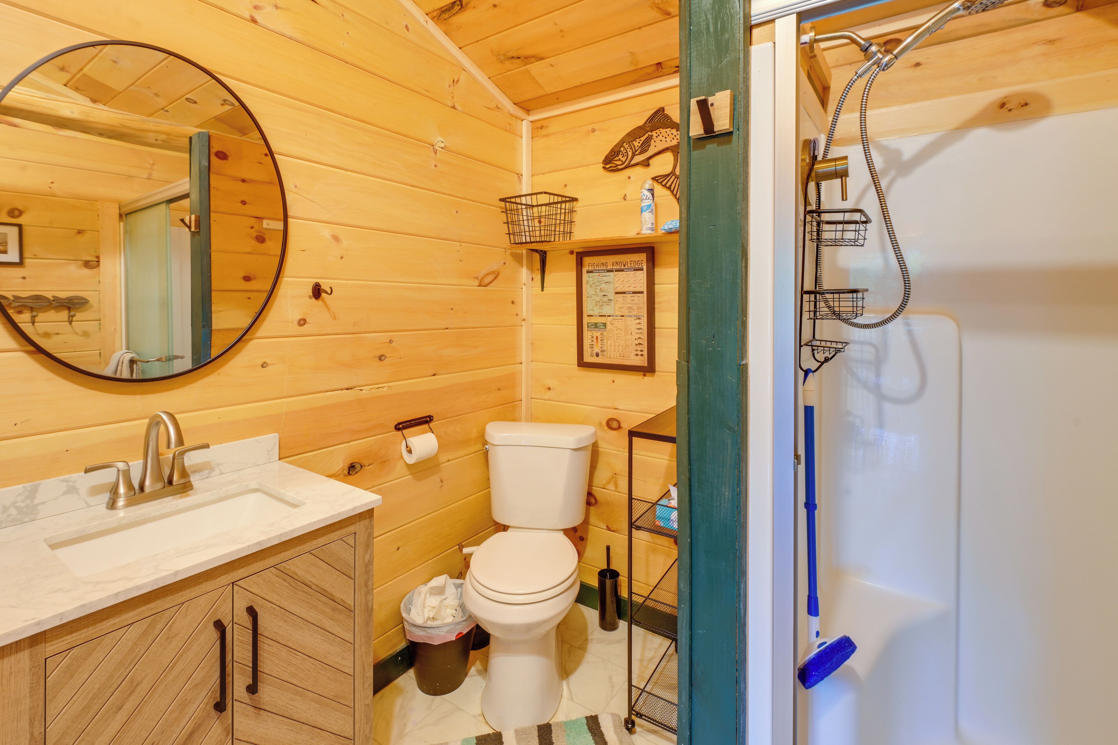 Een houten interieur met een wastafel, toilet en douche.