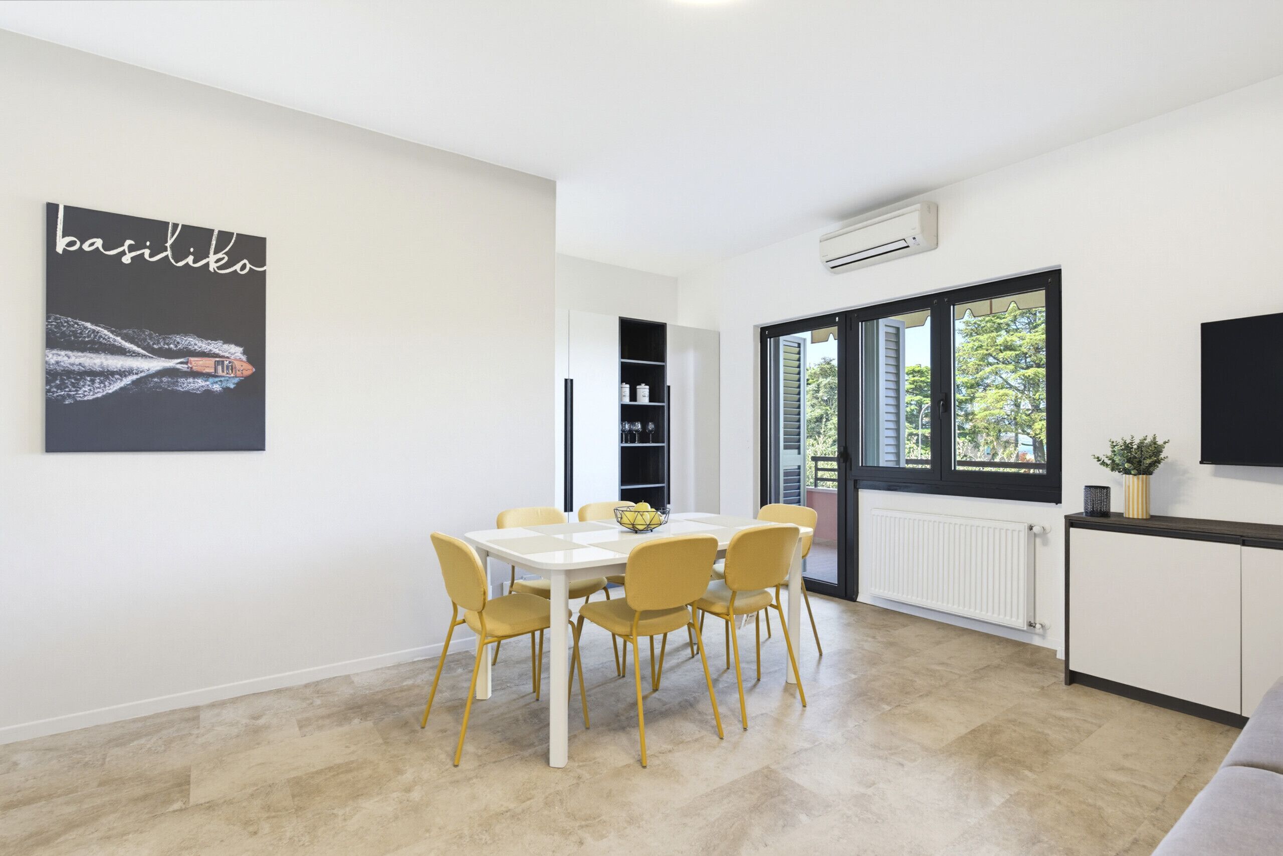 Una cocina moderna con una mesa de comedor, sillas y un ventanal grande.