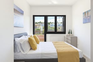 A bedroom with a bed, a window, and a view of buildings. - Regarda - Basiliko Sport Apartment with tennis and pool (Bardolino)