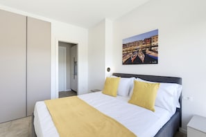 Ein Hotelzimmer mit Bett, Schrank, einem Bild einer Kanalansicht und einem Nachttisch.