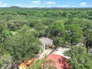 A house surrounded by dense forest with a clear view of the surrounding landscape. - Hillsedge Haciendas | Multi unit Hill Country Retreat with Hot Tubs (Wimberley)