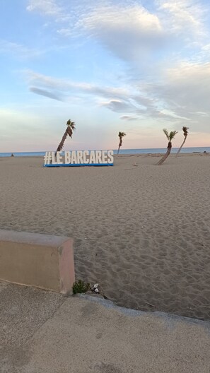 A beach with a sign reading '#LE BARCARES' and palm trees. - Air-conditioned apartment with a pool and a large terrace on the waterfront (Le Barcarès)