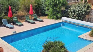 A rectangular swimming pool with a tiled edge, surrounded by a paved deck. - Air-conditioned apartment with a pool and a large terrace on the waterfront (Le Barcarès)